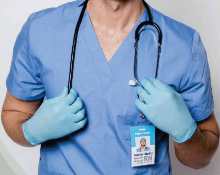Healthcare professional in clinical scrubs, gloves, and identification badge